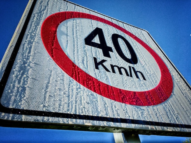 A close-up shot of a newly installed flashing speed limit sign in a school zone. The sign displays