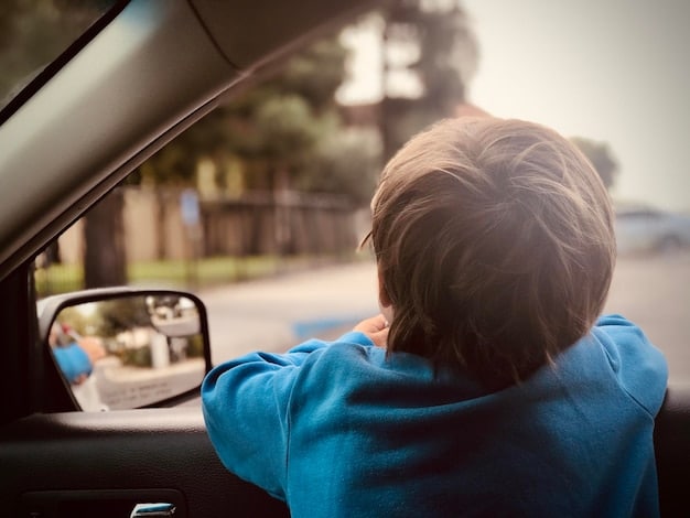A car interior scene with a driver reaching back to calm a child in the back seat. The child is slightly blurred, and the focus is on the driver's face showing mild distress and divided attention.