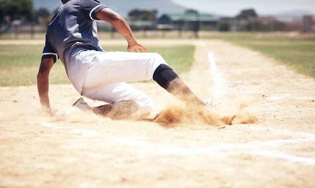 An action shot of a young baseball player sliding into second base during a game, with dust flying and the opposing player attempting to make the tag. The image highlights the excitement and athleticism of youth baseball.