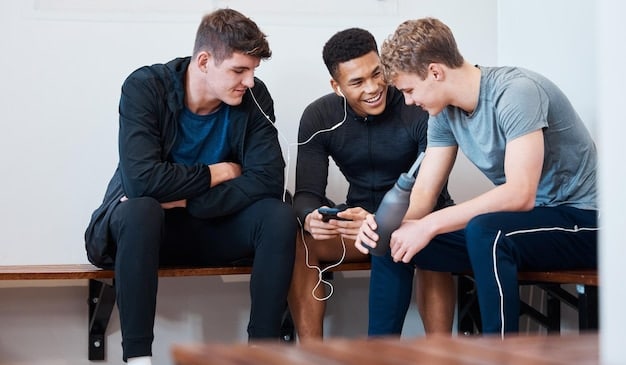 A coach kneeling down, speaking empathetically to a young male athlete who is sitting on the sidelines, looking dejected.