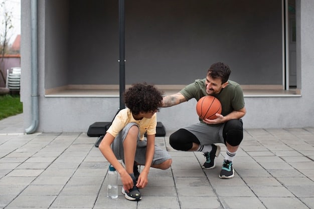 A volunteer coach demonstrates a basketball dribbling technique to a young player during practice. The coach has a supportive arm gently guiding the player's hand, and both are focused on the ball. Other teammates are practicing drills in the background.