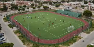 Vista aérea de un complejo deportivo moderno con campos de fútbol y canchas de baloncesto, reflejando el desarrollo de infraestructuras deportivas locales.