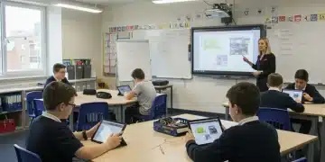 Aula escolar moderna con estudiantes usando tabletas y pizarras interactivas