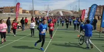 Evento deportivo comunitario al aire libre con participantes de todas las edades en España, mostrando alegría y actividad física.