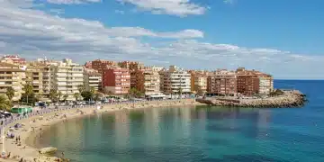 Paisaje costero español con edificios de alquiler turístico y viviendas tradicionales, reflejando el futuro del sector.