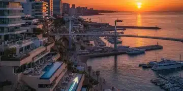 Paisaje costero español con edificios modernos y gráficos de crecimiento, simbolizando la revalorización inmobiliaria.