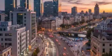 Paisaje urbano español al anochecer con cámaras de seguridad y patrullas policiales, simbolizando seguridad pública mejorada.